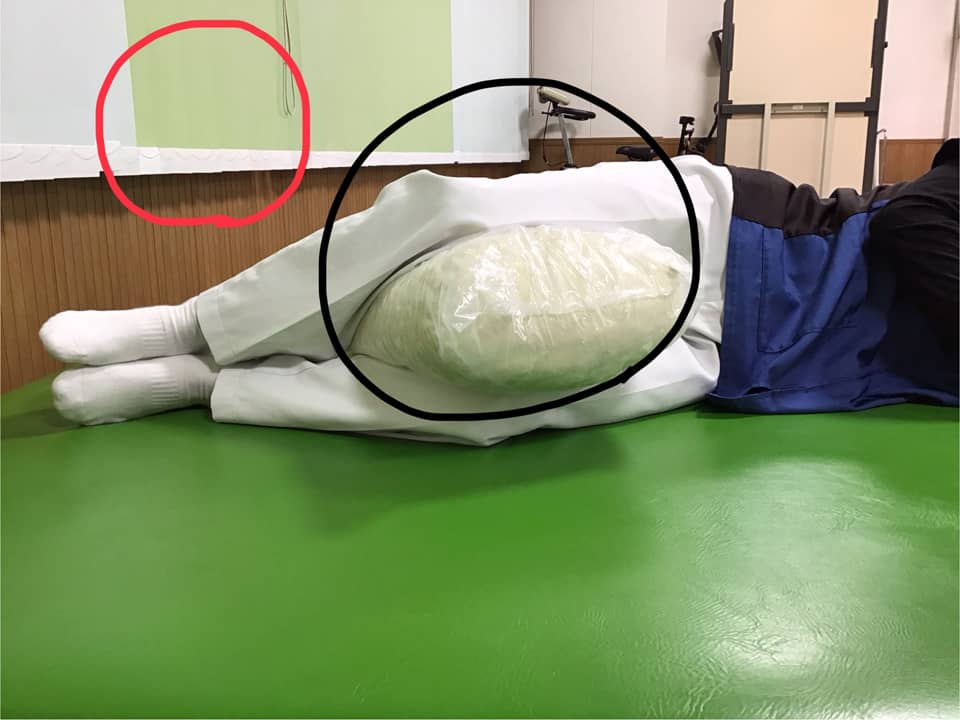 人工股関節置換術後に手術した足を上にして枕やクッションを挟んで横になった状態の写真
