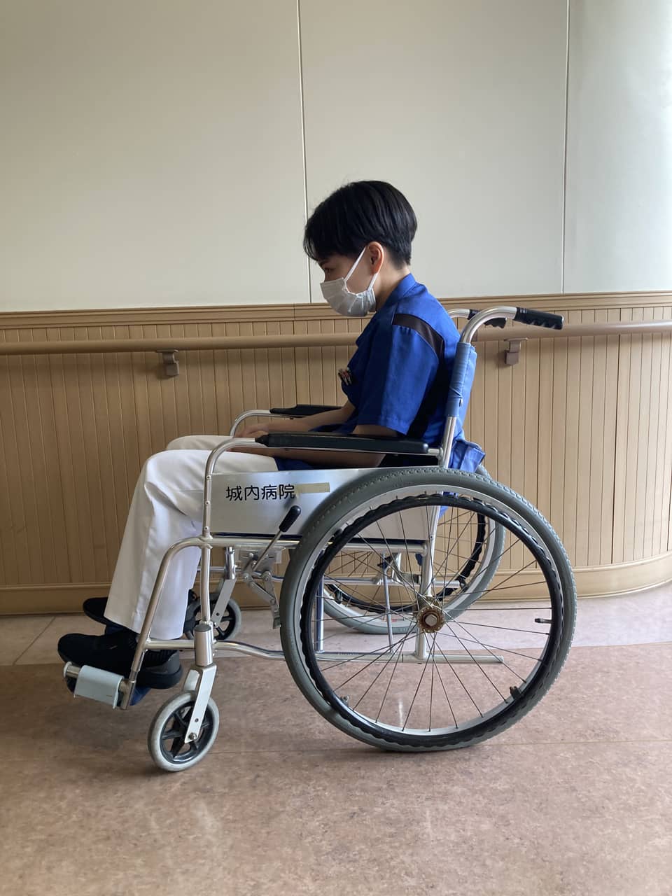 適合しない車椅子での崩れた座位姿勢の写真