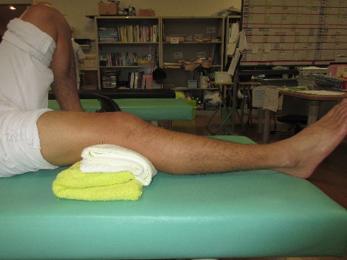 急性期のリハビリ 膝裏にタオルを置き、膝関節を伸ばす訓練の方法2