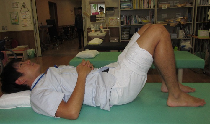 亜急性期のリハビリ 寝たまま膝を90度曲げて、片方ずつ交互に膝を伸ばす運動の方法1